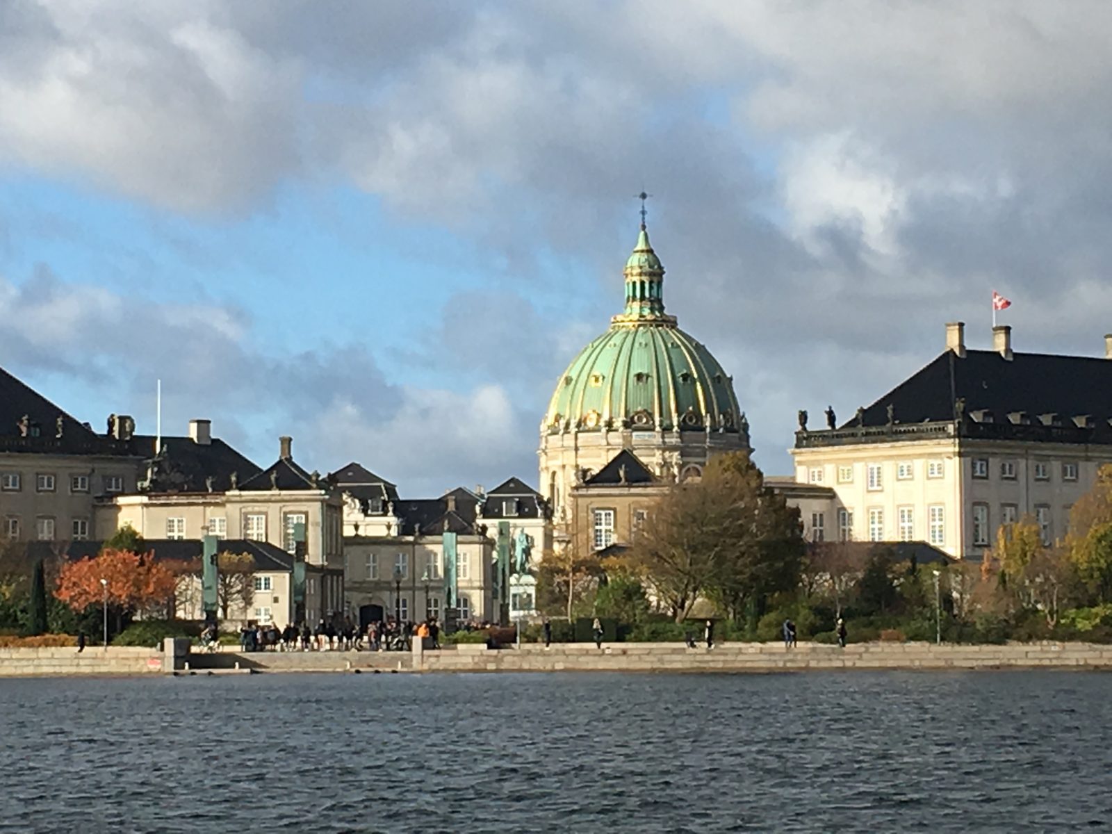 The green-and-gold dome of Frederik's Church (the Marble Church) rising behind the Amalienborg palace buildings, seen across the harbor.